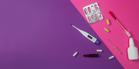 Cold medicines on pink and violet color background banner