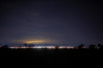 Clear desert skies and light from a small town at night
