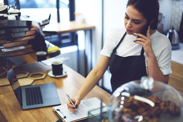Woman coffee house owner using laptop to check accountings from database, Restaurant entrepreneur