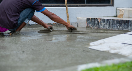 Workers are pouring, concrete and equipment
