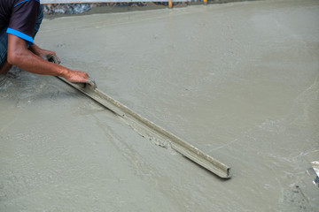 Workers are pouring, concrete and equipment
