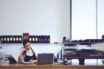  Female coffee shop cashier standing against copy space wall