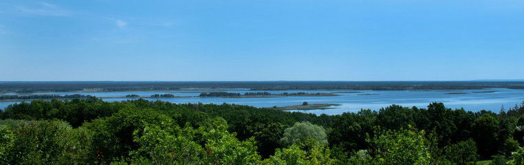 Fototapeta na wymiar Wide Big European River Dnieper- Panoramic View from the wooded shore on a summer day