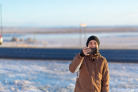 Guy tourist walks in winter in Iceland. Takes pictures of nature