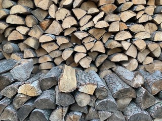 For the winter, ready-made chopped dry firewood. Background from logs, birch, pine and oak. A wall...