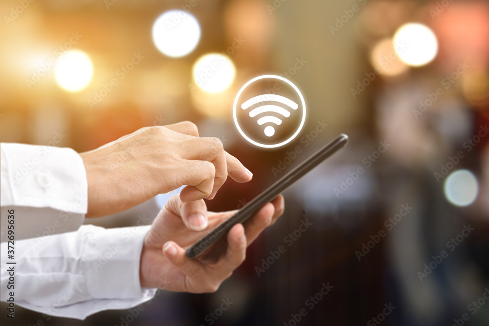 Wall mural man hand using mobile smartphone with wifi icon. idea for business communication social network.