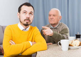 Aged father arguing with her adult son at home