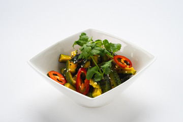 Traditional oriental salad of fresh vegetables in a deep white bowl on a white background, isolate.
