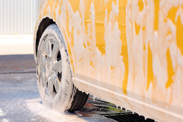 Modern automobile in foam at car wash, closeup