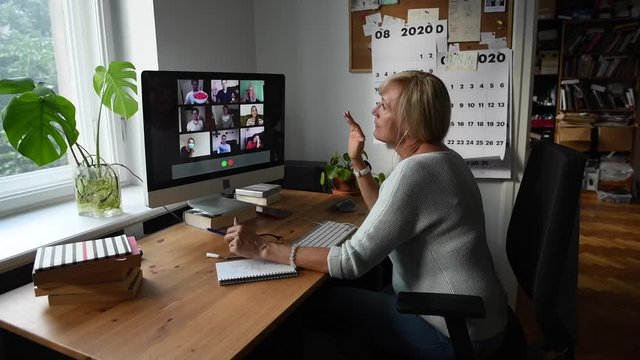 Woman having Zoom video call via a computer in the home office. Stay at home and work from home concept during Coronavirus pandemic.