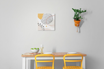 Table and chairs near light wall