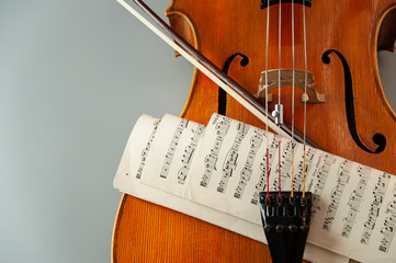 Fragment of cello or violin with bow and notes on a gray background and place for text © viktor