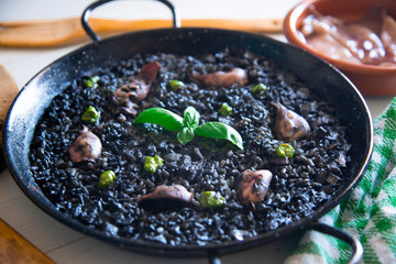 Black rice paella with chipirones and pesto made with pistachio and basilicum
