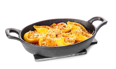 Baking dish with tasty conchiglioni pasta on white background