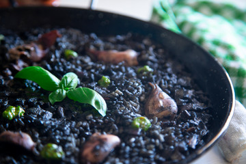 Black rice paella with chipirones and pesto made with pistachio and basilicum