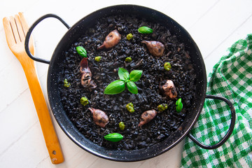 Black rice paella with chipirones and pesto made with pistachio and basilicum