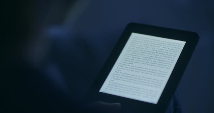 A woman reading an e-book in the evening or by night.