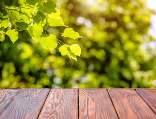 Naklejka na ściany i meble Wooden table and blurred green natural background. 