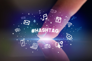 Finger touching tablet with drawn social media icons and #HASHTAG inscription, social networking concept