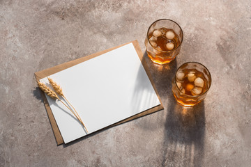 Blank card mockup, cold drink with long shadows and ears of ripe wheat. Modern stationery scene....