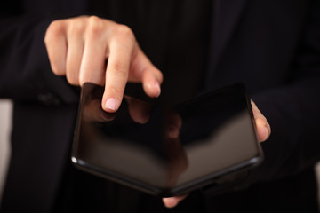 Young man holding a foldable smartphone with ADVANCED TRAINING inscription, educational concept LEADER