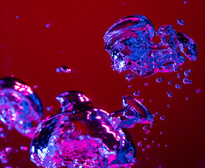 Close up view of the cold and fresh cola with bright bubbles in neon light. Texture of cooling summer's drink with macro bubbles on glass. Fizzing or floating up to top of surface, splashing fluid.