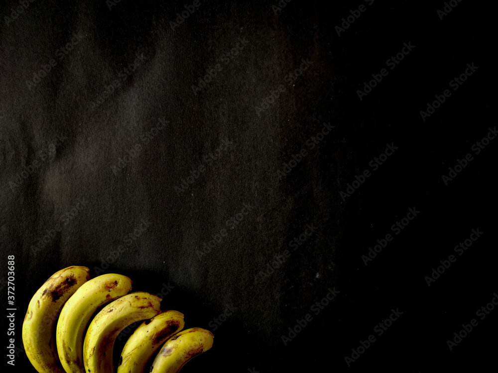 Wall mural five bananas isolated on black background. copy space