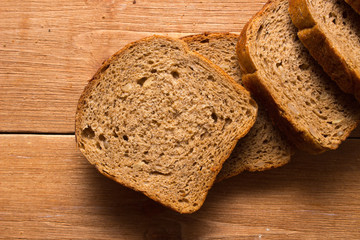 Assortment of baked bread on wooden table background