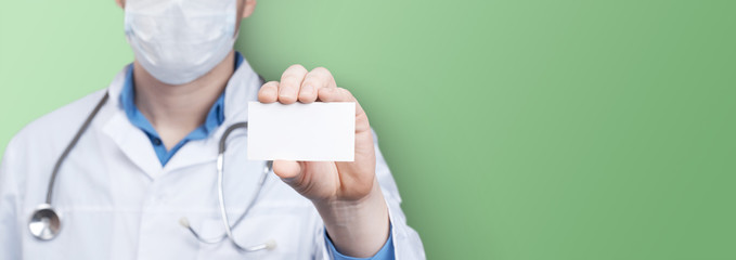 Doctor in a mask holging a empty business card