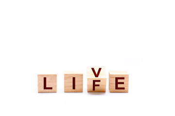 Spinning wooden dice by changing the word LIFE to LIVE