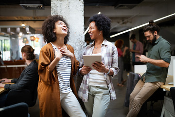 Working together on project. Happy young business colleagues working in office