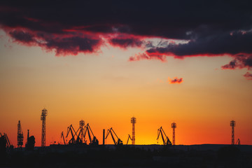 Naklejka premium Sea port and industrial cranes, Varna, Bulgaria.Sunset over the Varna lake