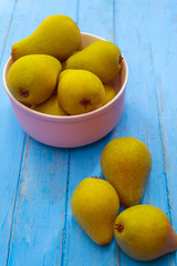 Wild pears ripe and juicy lie in a deep plate of purple color