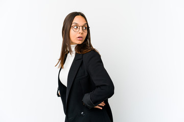 Young mixed race business woman isolated on white background looks aside smiling, cheerful and pleasant.