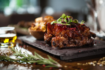 Pork ribs cooked at low temperature. Blackcurrant sauce, parsnip chips with Parmesan cheese. Delicious healthy meat food closeup served on a table for lunch in modern cuisine gourmet restaurant