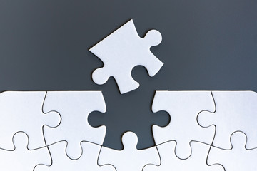 White jigsaw puzzle pieces on gray background