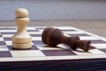 The end of the chess game, the white pawn defeated the dark king. Business concept copy space,...
