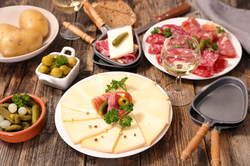 raclette cheese, salami and prosciutto ham with wine and potato