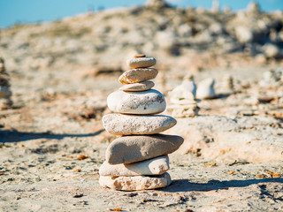 Fototapeta na wymiar Hito de piedras sobre la arena de la playa