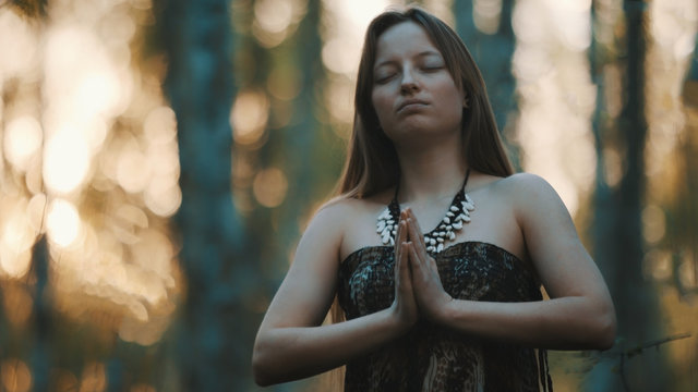 Female sorcerer in the woods. Prayer or magical ritual. High quality photo