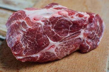 A piece of fresh meat. Raw marbled pork in a cut on a wooden cutting board. A piece of juicy meat for a delicious dish, the concept of correct nutrition.