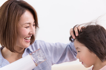 ドライヤーで娘の髪を乾かす母