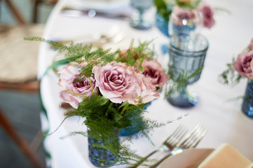 Powder roses in small blue vases.Wedding decor or romantic date design. Floristics.
