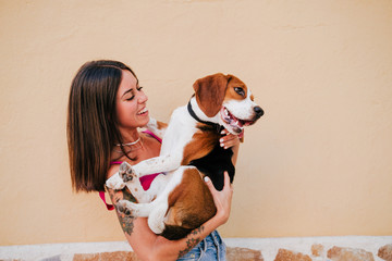 happy young woman outdoors having fun with beagle dog. Family and lifestyle concept. yellow...