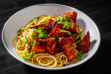 Spaghetti pasta with fried pork in bowl