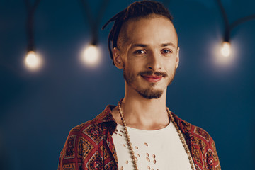 Close-up portrait of a young stylish man with dreadlocks