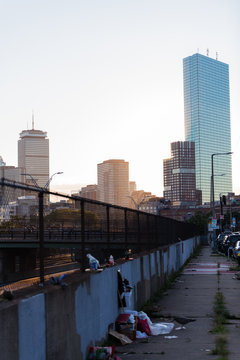 Street photo of downtown Boston showing the contrast of skyscrapers to the streets where homeless live 