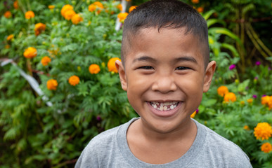 Boy smiling face portrait On a garden background.