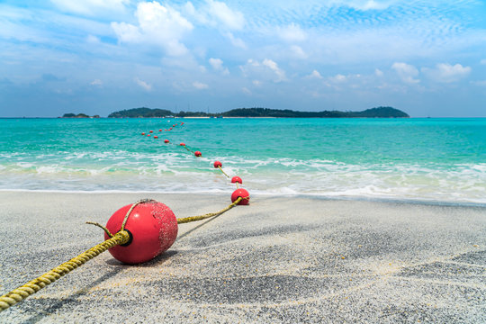 Red buoy on beach and sea