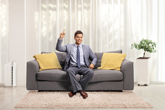 Man In Elegant Clothes Sitting On A Sofa At Home